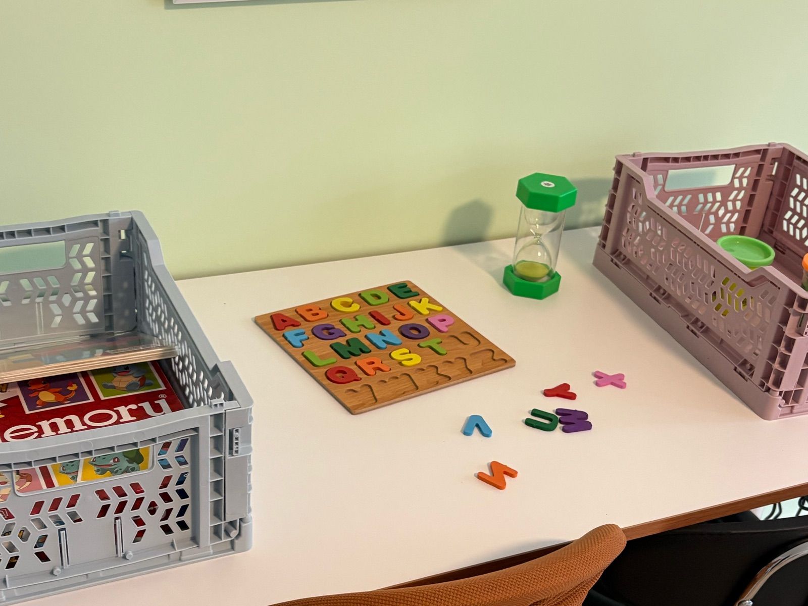 Therapietisch mit Materialkisten, Buchstabenpuzzle und Sanduhr